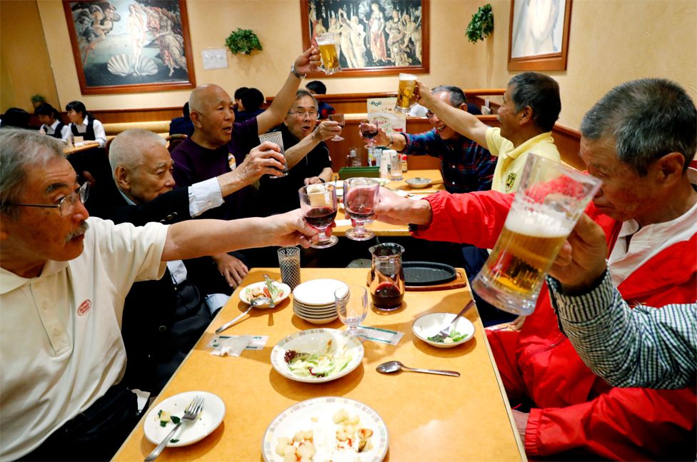 Members of Tokyo's Fuwaku Club raise their glasses in a restaurant
