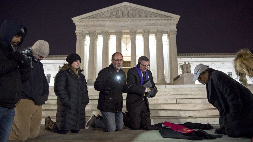 People pray in front of the US Supreme Court after the death of Justice Antonin Scalia