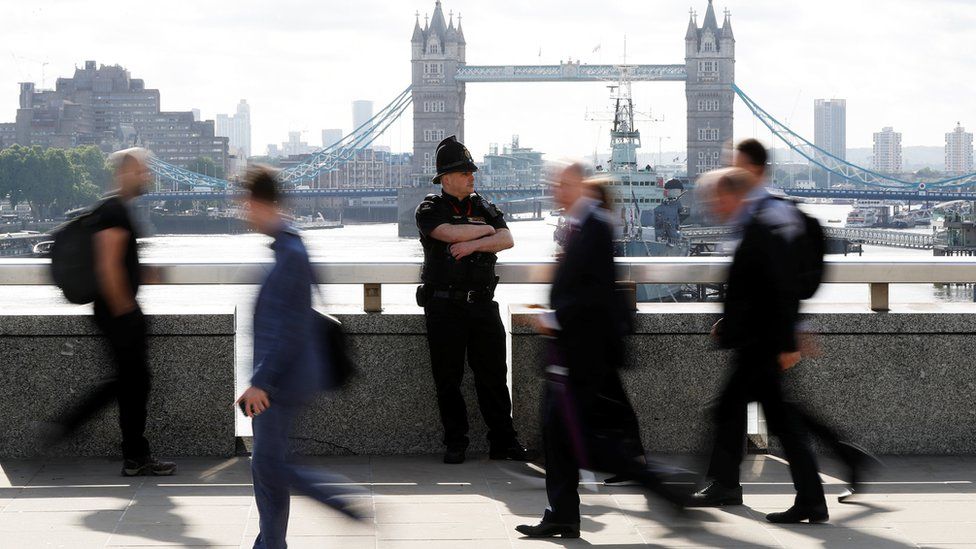 Police and commuters on bridge