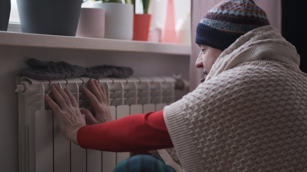man feeling cold at home with home heating trouble