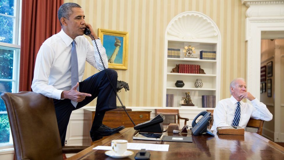 Barack Obama on the phone with Speaker of the House Boehner as Vice President Joe Biden listens in the Oval Office, 31 August 2013
