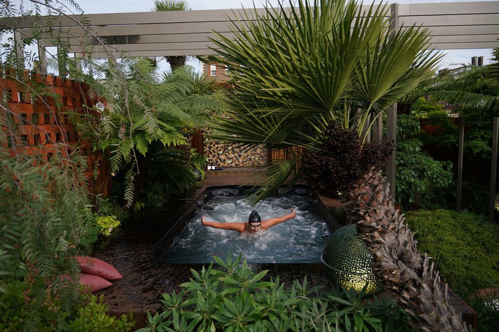 A woman uses a garden with a hot tub during the RHS Chelsea Flower Show press day, at the Royal Hospital Chelsea, London