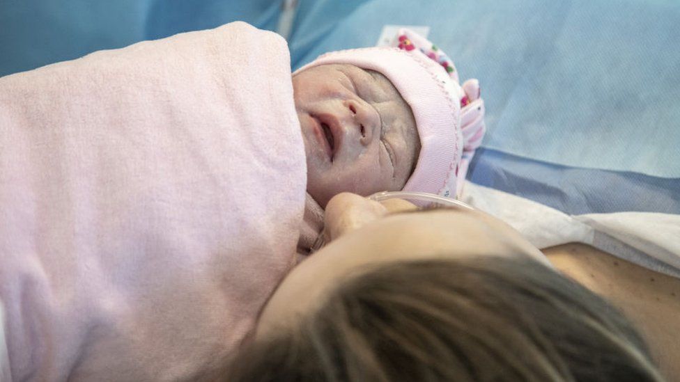 Olga, 30, kisses her new-born child at a maternity hospital in Lviv, Ukraine, 10 May 2023