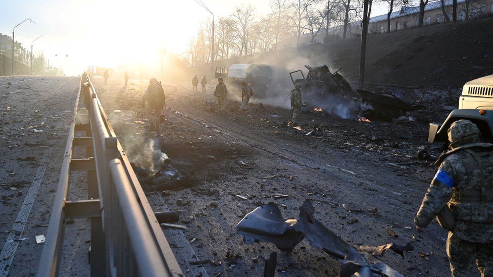 Ukrainian service members are seen at the site of a fighting with Russian raiding group in the Ukrainian capital of Kyiv in the morning of February 26, 2022