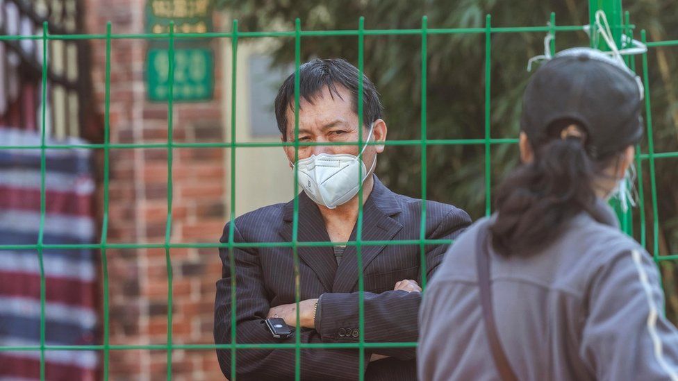 A woman talks with a person in quarantine through the fence, amid new Covid-19 lockdown, in Shanghai, China, 10 October 2022