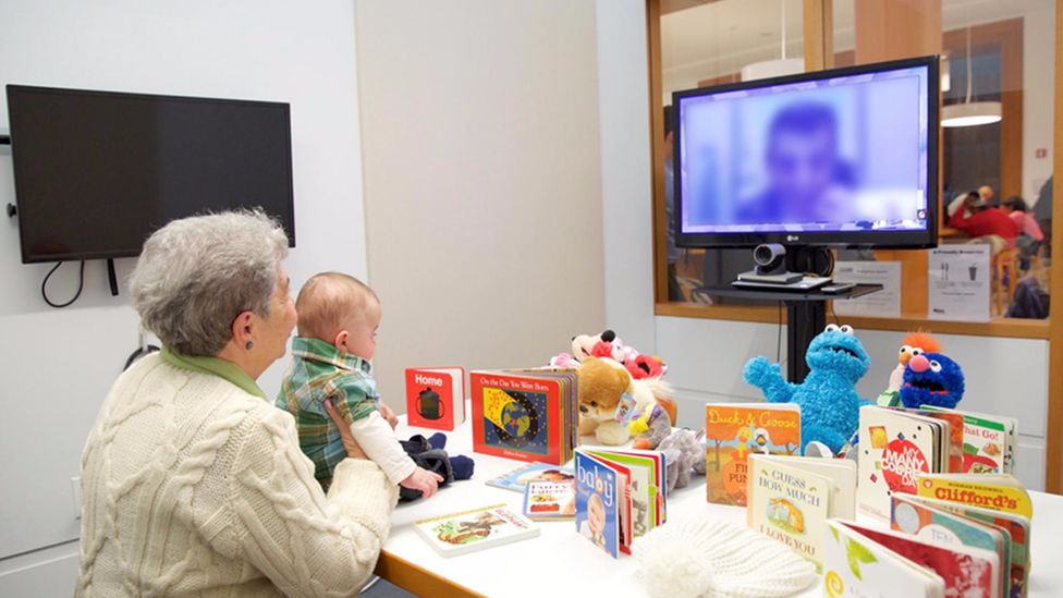 Baby being read to via video