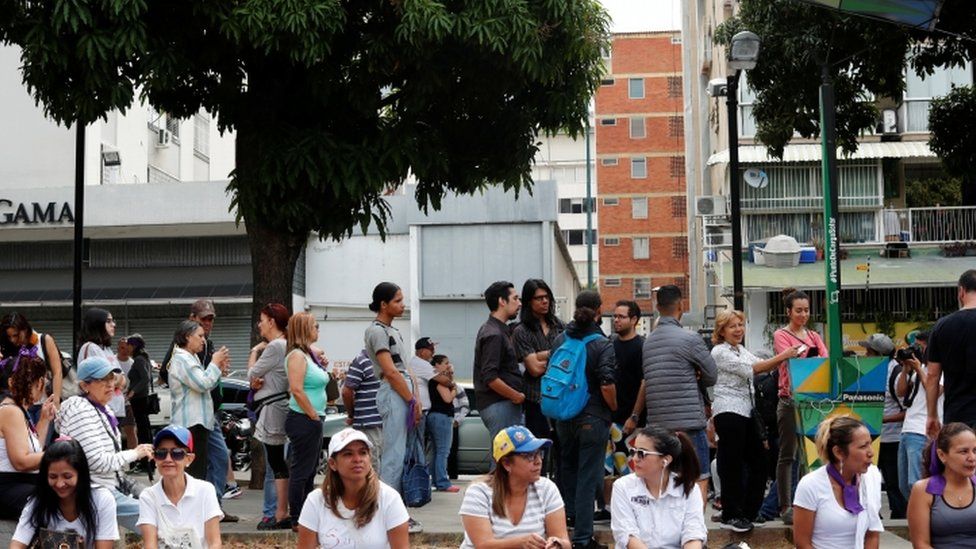 Gente haciendo cola para cargar sus teléfonos.