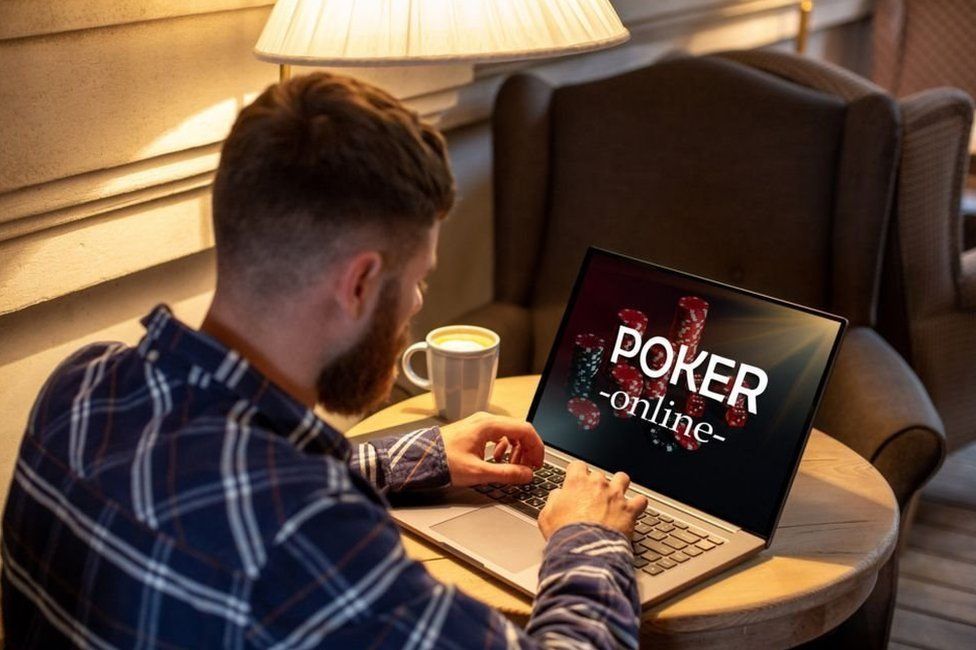 A man types on a laptop open at the screen for online poker