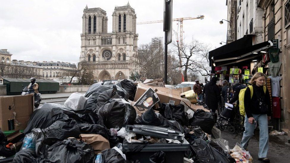 household waste near the Notre-Dame cathedral, that has been piling up on the pavement as waste collectors are on strike since March 6 against the French government's proposed pensions reform