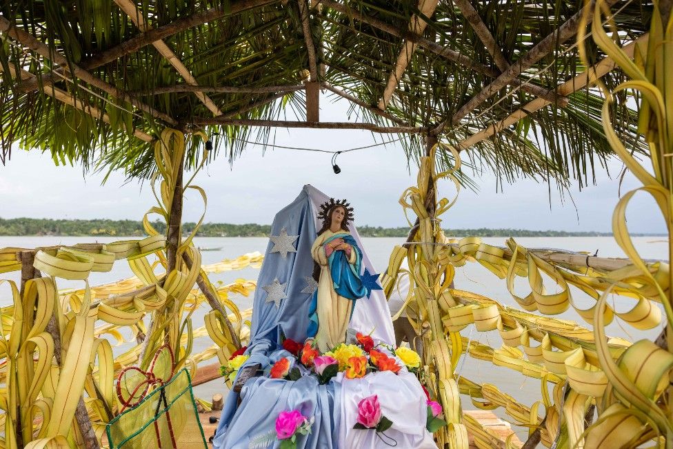 Когда наступает ночь, статую Девы Марии доставляют на плоту в город. Гуапи, Каука. 07 декабря 2022 г.
