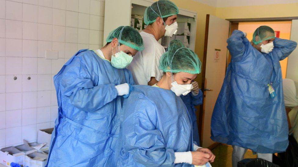Members of the medical staff put on personal protective equipment (PPE) at the Covid-19 unit of the Policlinico Sant'Orsola-Malpighi hospital in Bologna on April 15, 2020