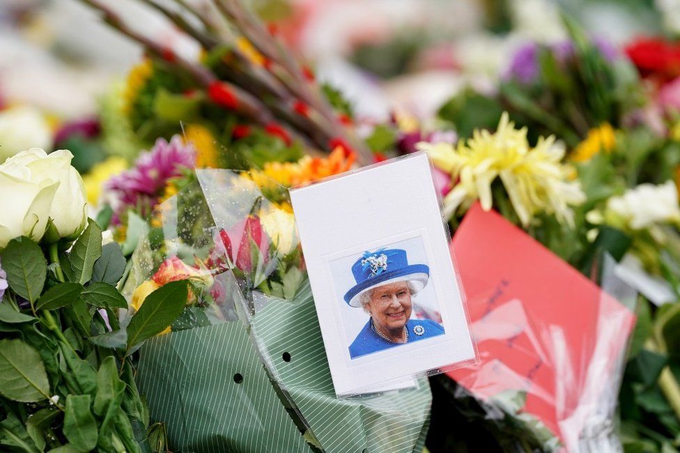 Floral tributes and a photo of the Queen