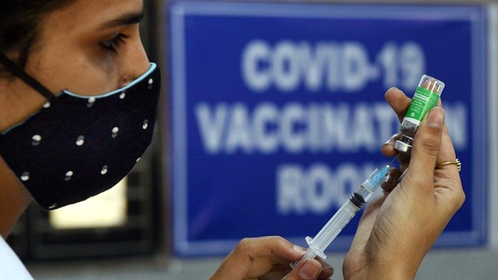 เจ้าหน้าที่สาธารณสุขเตรียมฉีดวัคซีนป้องกันโควิด-19 ระหว่างการขับวัคซีนในนิวเดลี