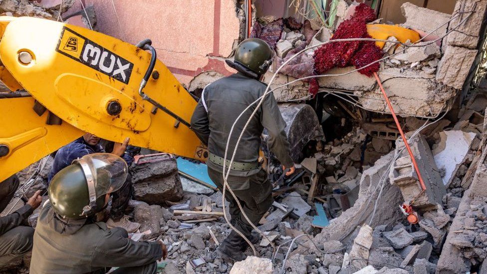 Rescuers use a small excavator to search for survivors under the rubble in Marrakesh