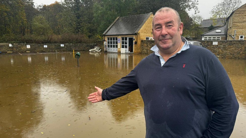James Little in front of floodwater