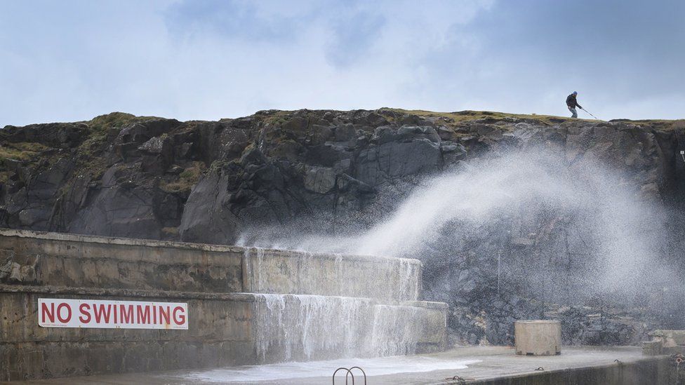 Wave crashing over sea wall in Portstewart