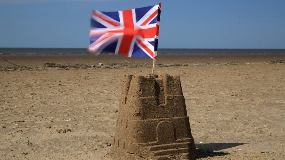 Sandcastle on Southwold beach with Union flag flying from the top