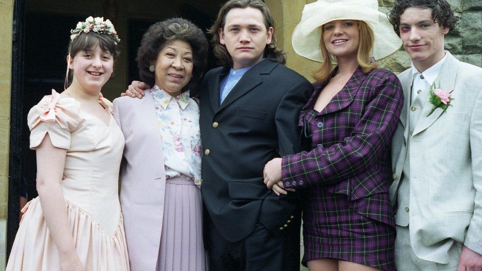 EastEnders stars Natalie Cassidy, Mona Hammond, Sid Owen, Patsy Palmer and Dean Gaffney in 1996, at the wedding of Carol and Alan