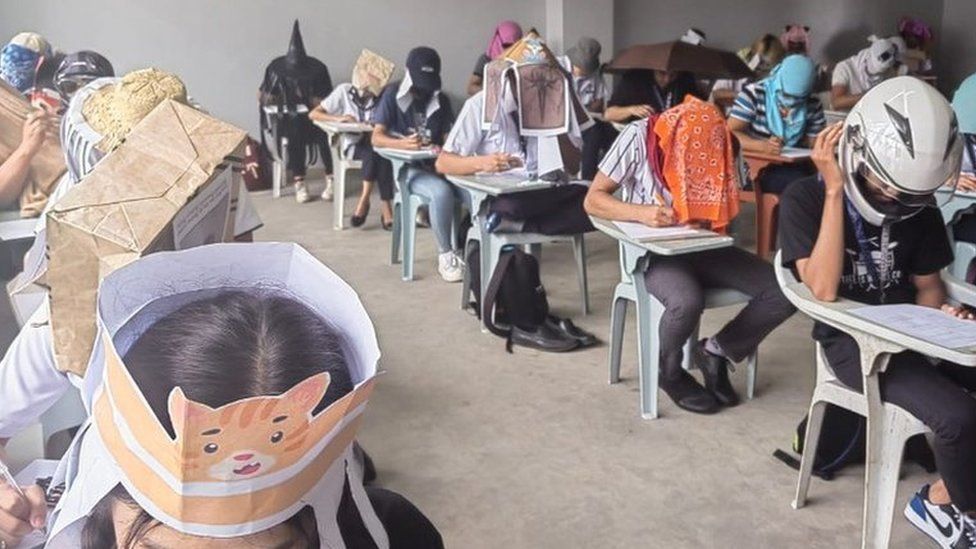 Students wear homemade "anti-cheating hats" in a classroom in the Philippines