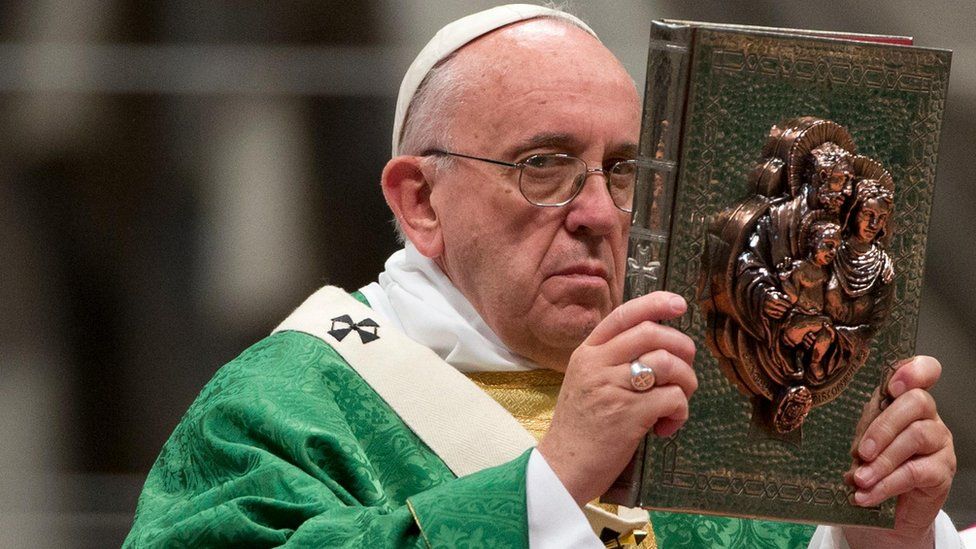 Pope Francis lifting the book of the Gospels during Mass at St Peter's (4 October)