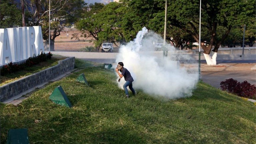 A man reacts to tear gas near the Generalisimo Francisco de Miranda Airbase "La Carlota", in Caracas, Venezuela April 30, 2019.