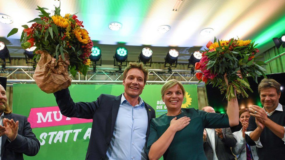 Green leaders Ludwig Hartmann and Katharina Schulze celebrate after hearing exit polls