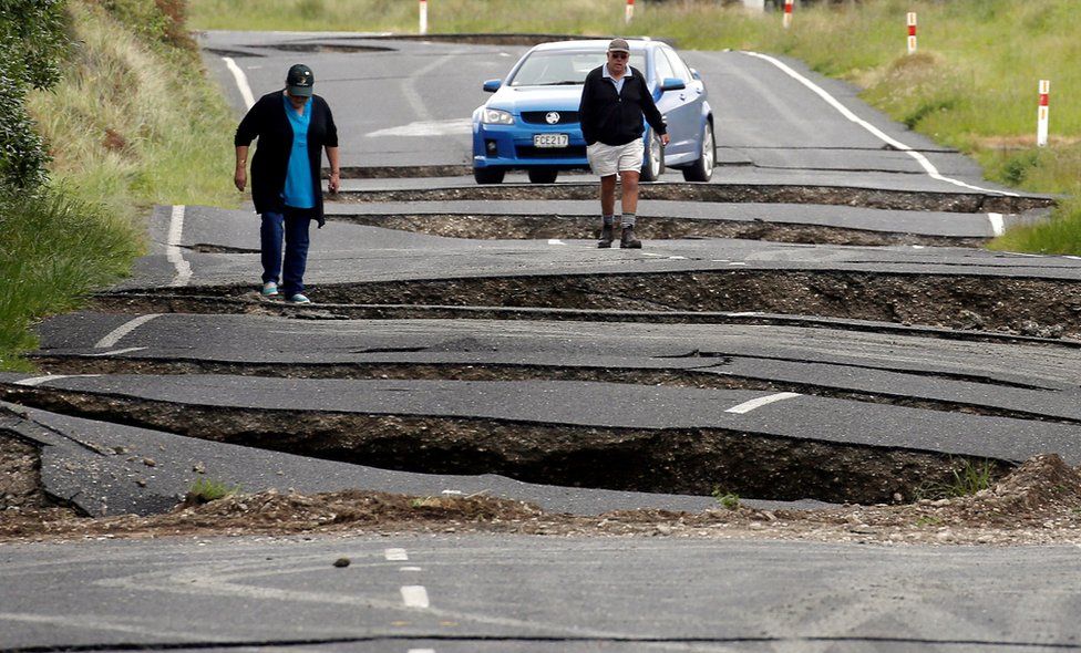 Local residents Chris and Viv Young look at damage caused by an earthquake, along State Highway One near the town of Ward, south of Blenheim on New Zealand's South Island, 14 November 2016