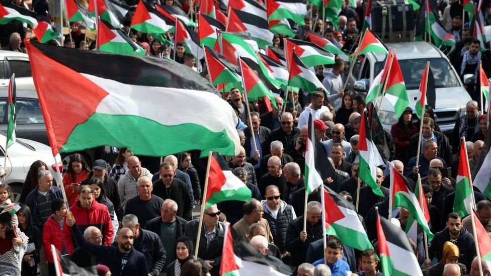 Protesters wave Palestinian flags during a demonstration marking the annual Land Day in the northern Arab-Israeli town of Sakhnin on March 30, 2023