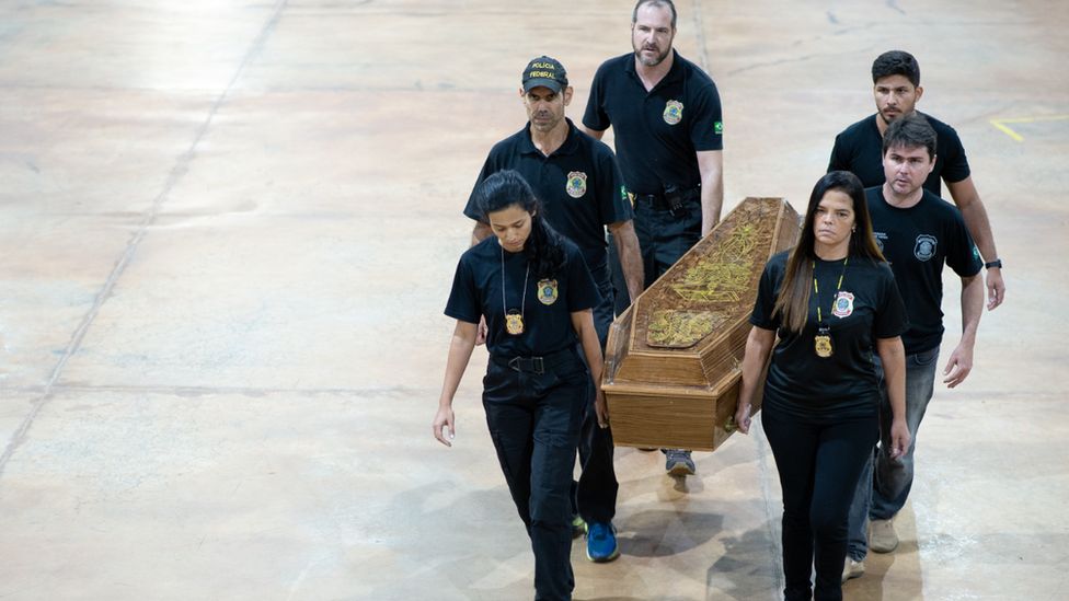 Бразильские полицейские перевозят гроб с человеческими останками, найденный в отдаленных тропических лесах Амазонки. Фото: 16 июня 2022