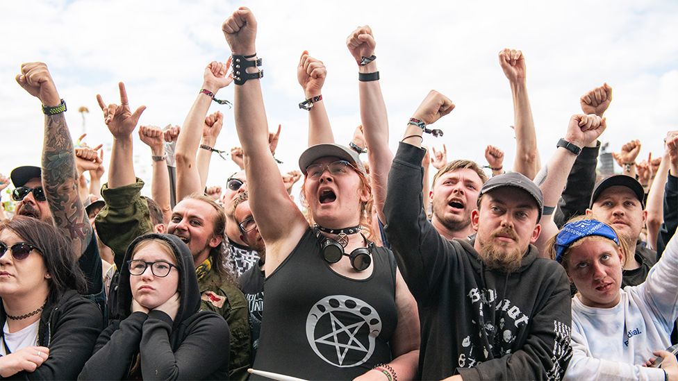 Festival goers with arms raised at the main stage of Download festival at Donnington Park