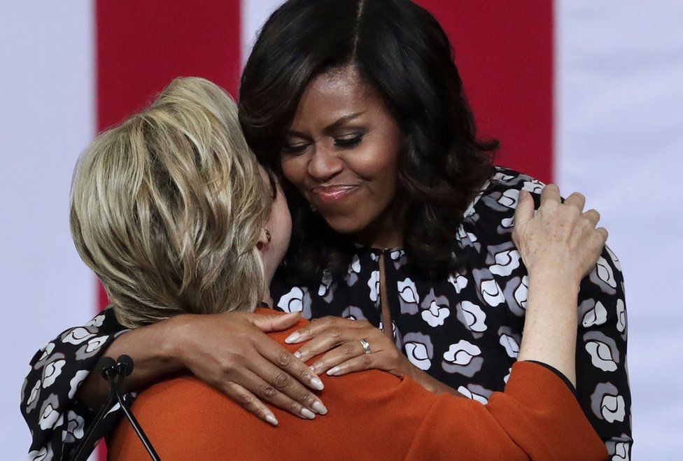 Hillary Clinton (L) and Michelle Obama (R) embrace