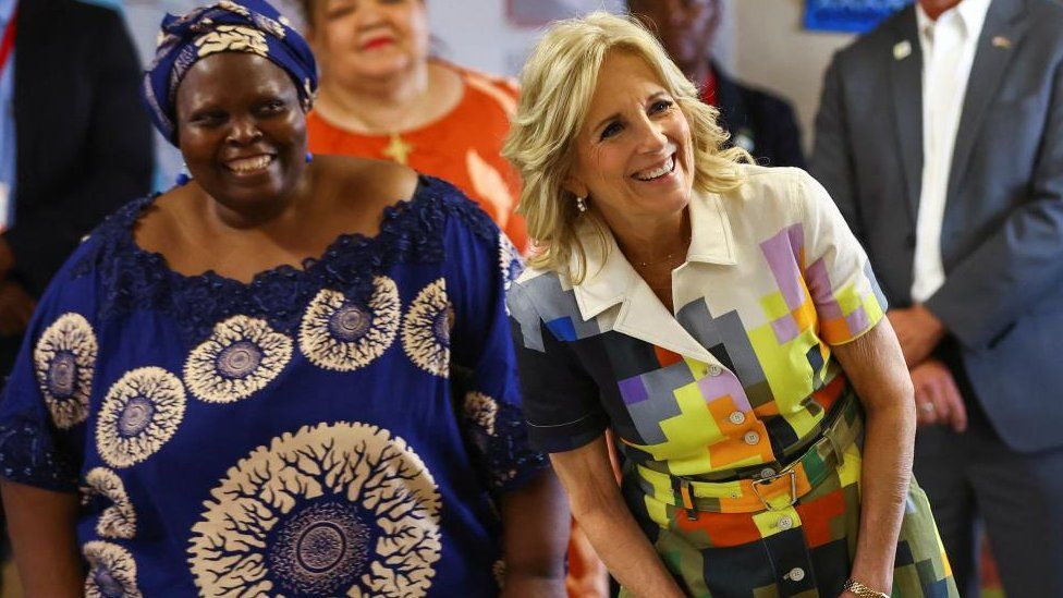 U.S. first lady Jill Biden reacts next to Patricia Sola, founder of Hope Initiative Southern Africa, at the center, in Windhoek, Namibia, February 23