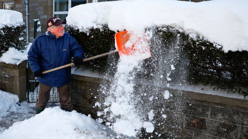 A man clears snow from his home