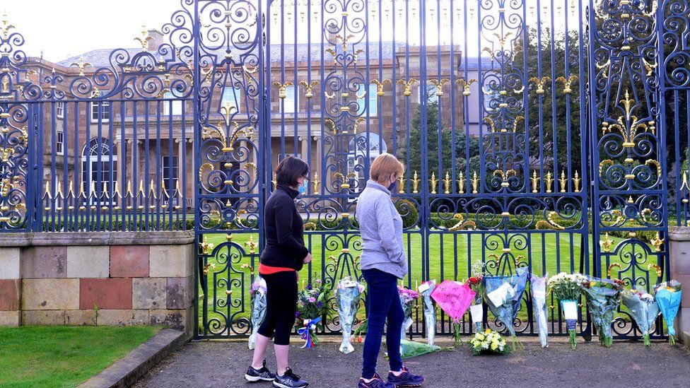 Members of the public leave flowers outside Hillsborough Castle the official residence of Queen in Northern Ireland for the Duke of Edinburgh, who died in April