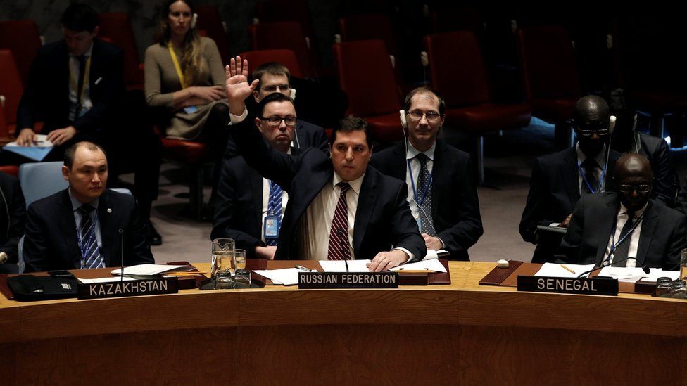 Russian Deputy Ambassador to the United Nations Vladimir Safronkov raises his arm to vote against a United Nations Security Council resolution