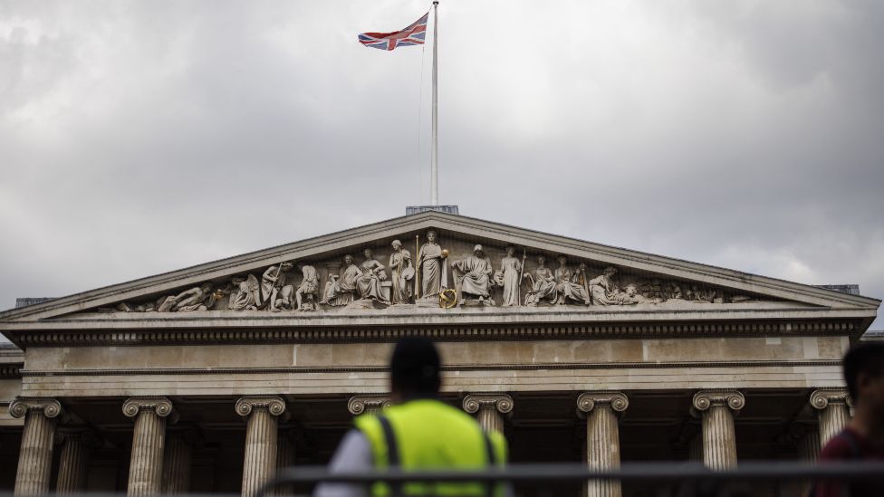 Юнион Джек развевается на вершине Британского музея, пока сотрудники службы безопасности регулируют поток посетителей в Лондоне, Великобритания, 17 августа 2023 г.