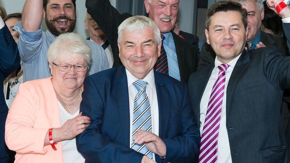 George Robinson, centre, flanked by his wife Ann and son Alan, celebrates with his fellow members of the DUP aft