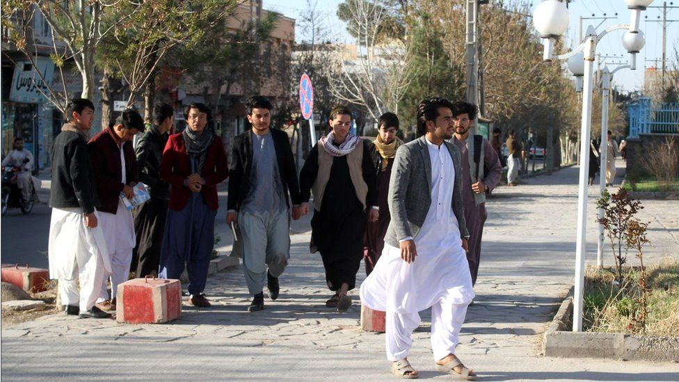 Male students arrive at Herat University after it reopened on March 6, 2023.