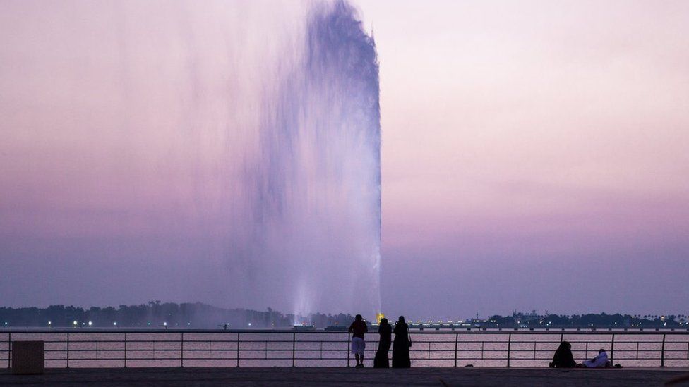 People looking at King Fahd's Fountain as the sun sets