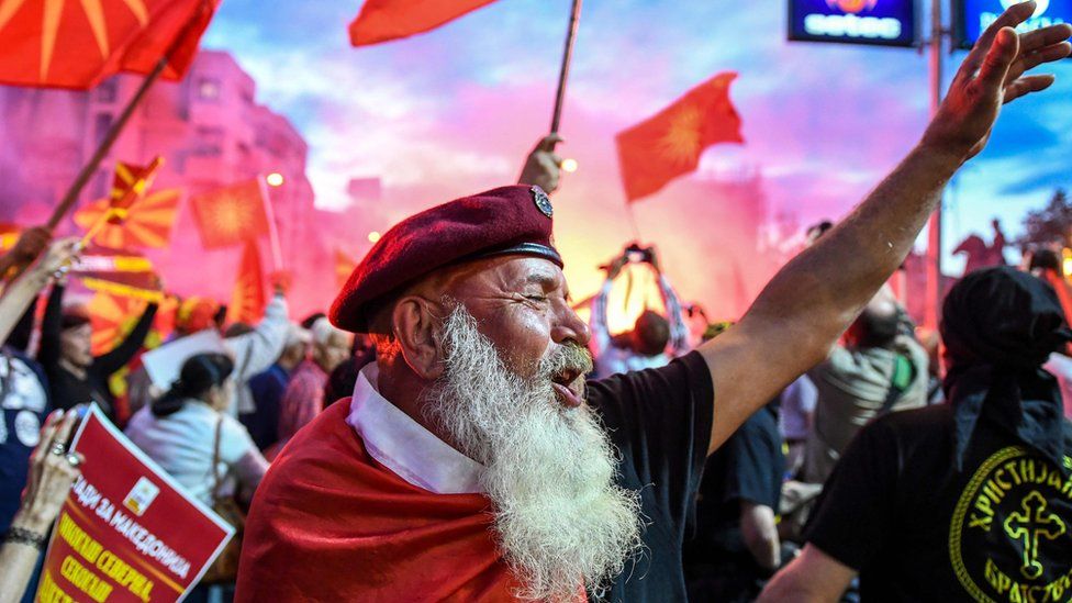 Demonstrators wave flags in front of the parliament building in Skopje on June 23, 2018 during a protest against the new name of the country, the Republic of North Macedonia.