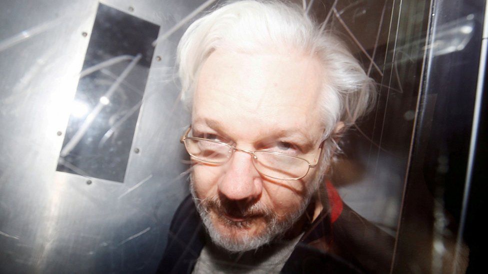 Julian Assange, with his face close tom a camera, leaves Westminster Magistrates Court in London (file photo from 2020)