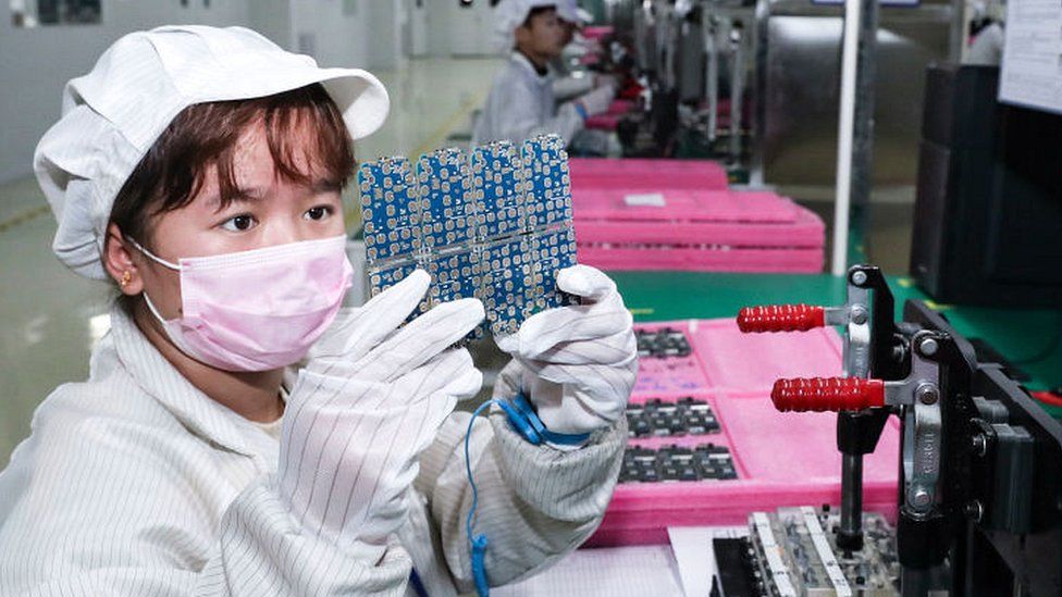 Employees work on the assembly line of printed circuit board for smartphone at a factory on January 7, 2021 in Jiangsu Province of China