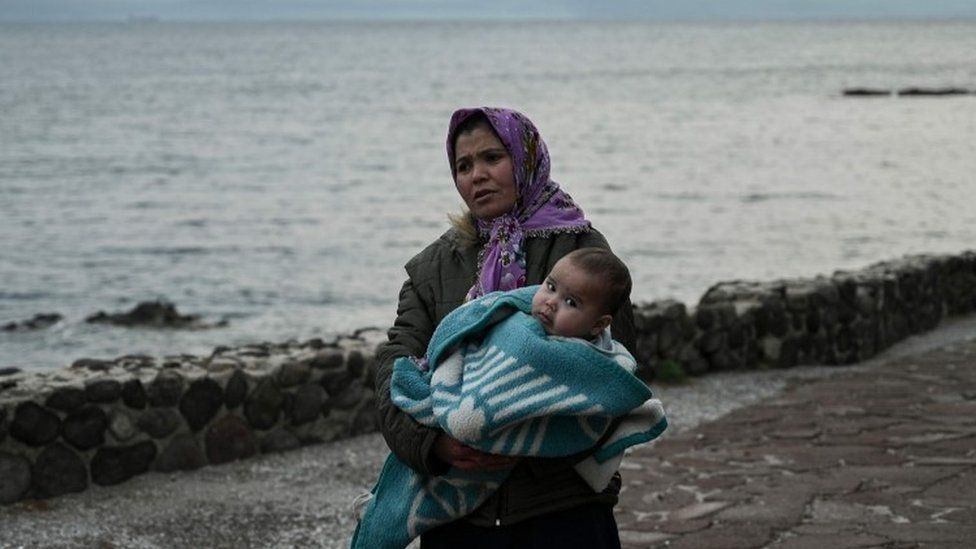 Женщина-мигрант с ребенком на руках на Лесбосе