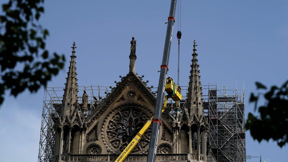 Workers cover and protect the Rosette of Notre-Dame de Paris Cathedral in Paris on April 22, 2019, seven days after a fire devastated the cathedral.