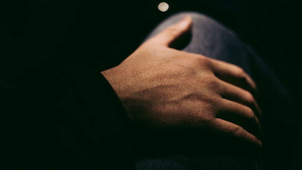 Woman's hand resting on her leg