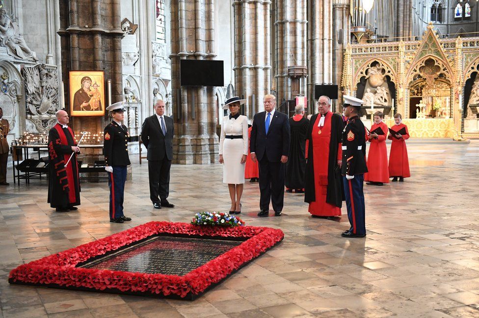 US President Donald Trump, accompanied by his wife Melania and Prince Andrew, Duke of York, places a wreath on the grave of the unknown warrior during a visit to Westminster Abbey