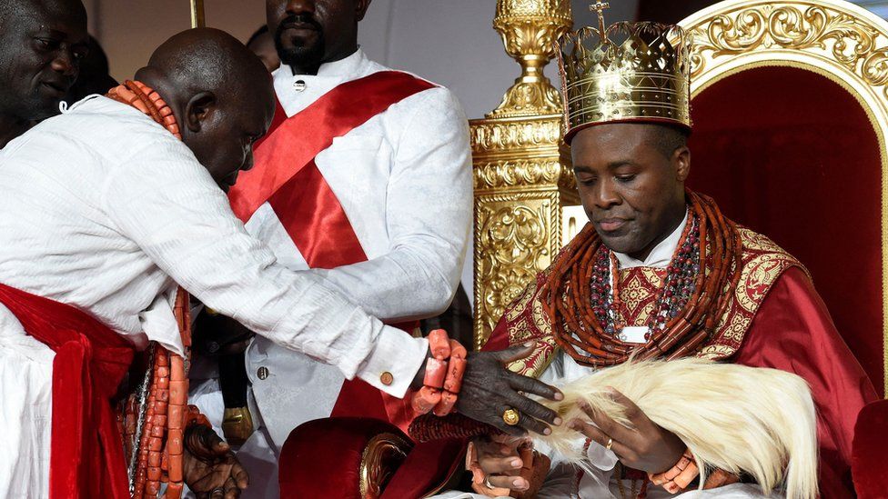 A kingmaker presents a gift to Prince Tsola Emiko during his coronation