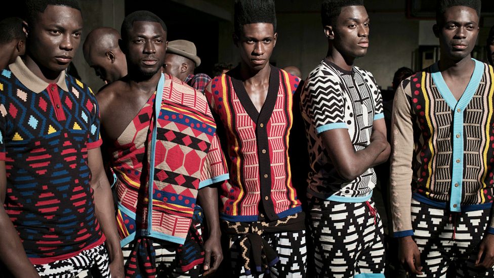 Models in clothes by fashion designer Laduma Ngxokolo wait backstage before a show in Cape Town, South Africa - archive shot