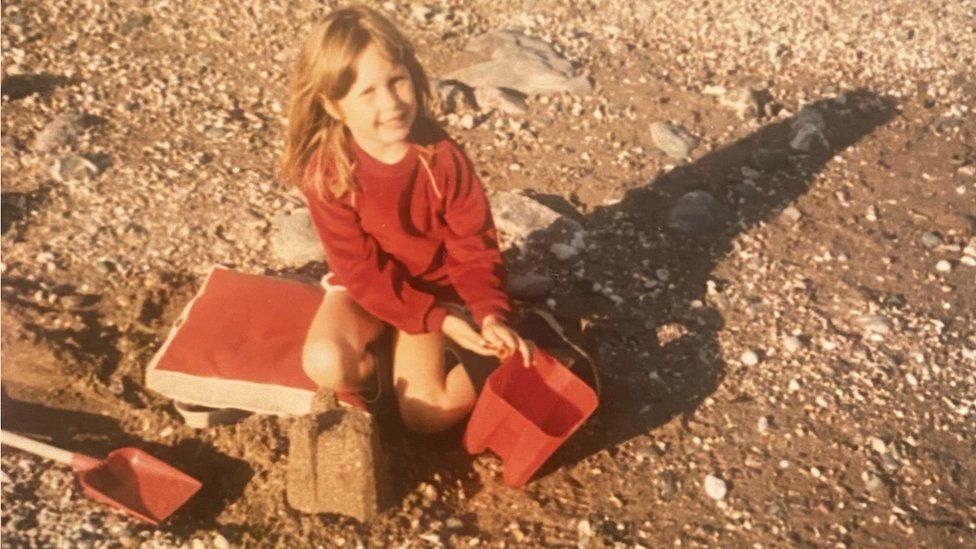Christina on the beach with a bucket and spade in about 1985
