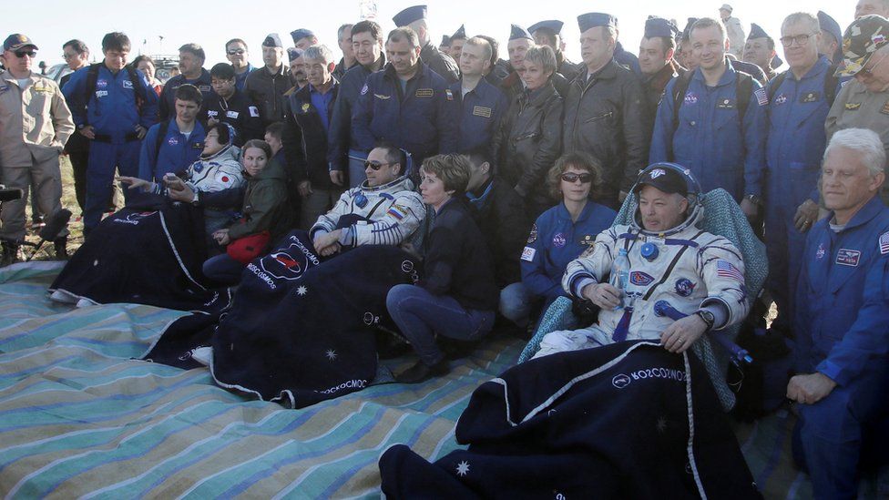 The three astronauts with ground crew at the landing site. 3 June 2018